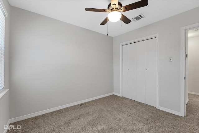 unfurnished bedroom featuring ceiling fan, a closet, and carpet floors