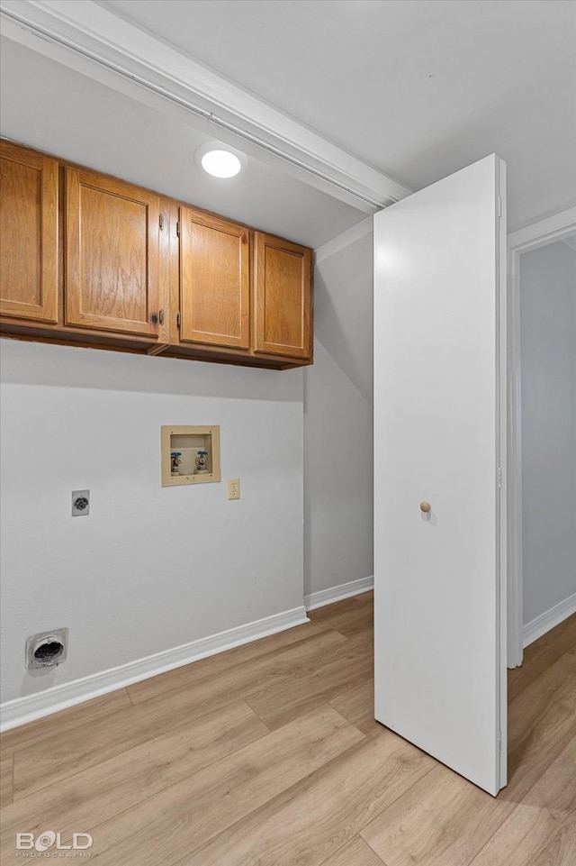 laundry area with electric dryer hookup, cabinets, light hardwood / wood-style flooring, and washer hookup