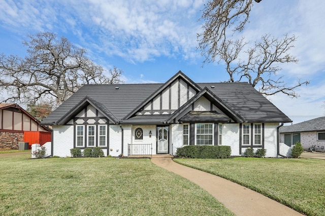 tudor-style house with a front yard and central AC unit