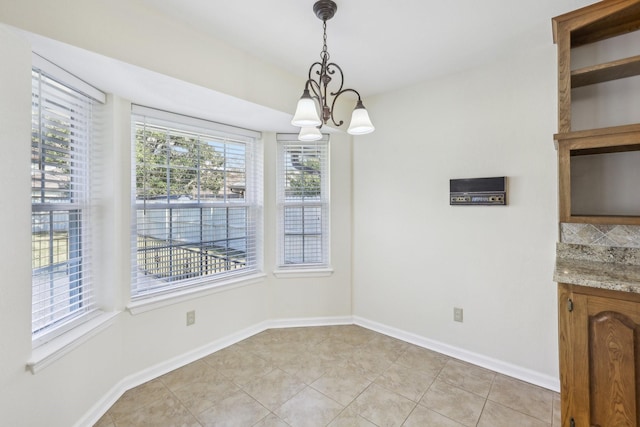 unfurnished dining area featuring a notable chandelier and light tile patterned flooring