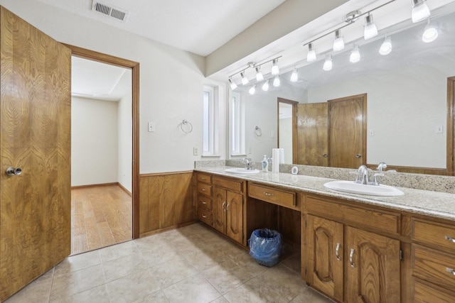 bathroom with tile patterned flooring, vanity, and wood walls