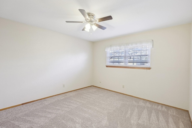 carpeted spare room featuring ceiling fan