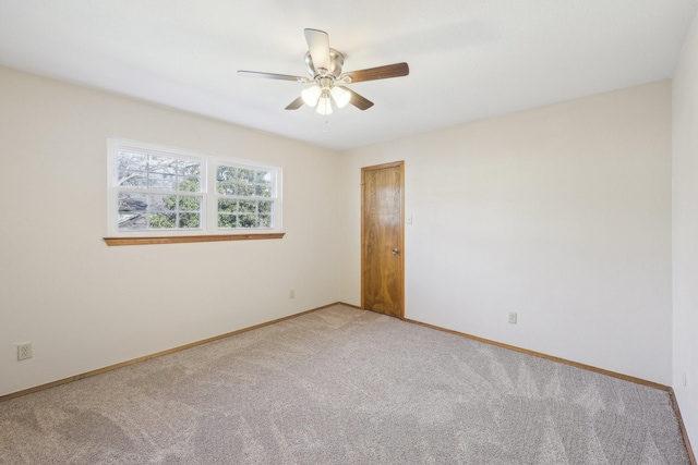 carpeted spare room featuring ceiling fan