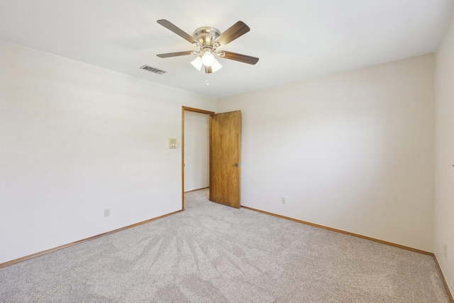 carpeted spare room with ceiling fan