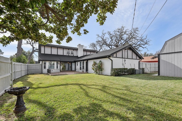 rear view of property featuring cooling unit and a yard