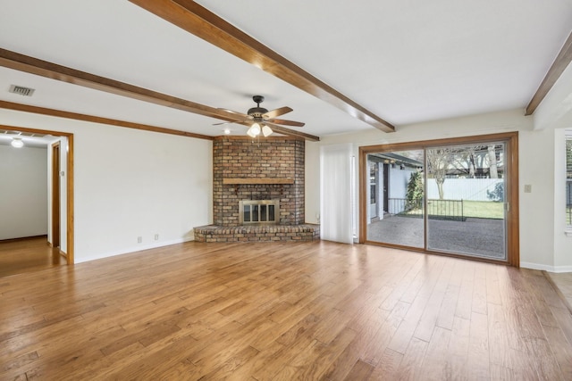 unfurnished living room with ceiling fan, beam ceiling, light wood-type flooring, and a fireplace