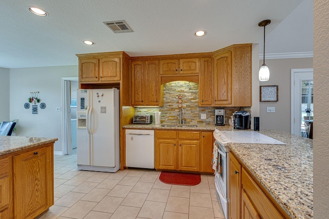 kitchen featuring light tile patterned flooring, sink, light stone counters, decorative light fixtures, and white appliances