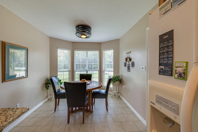 dining room featuring light tile patterned floors and a textured ceiling