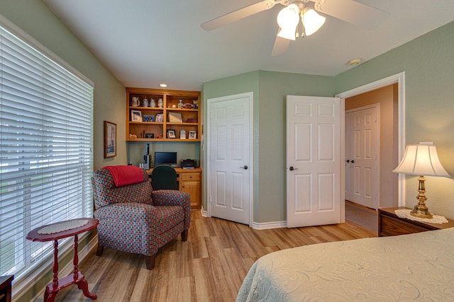 bedroom featuring ceiling fan, built in desk, and light hardwood / wood-style floors