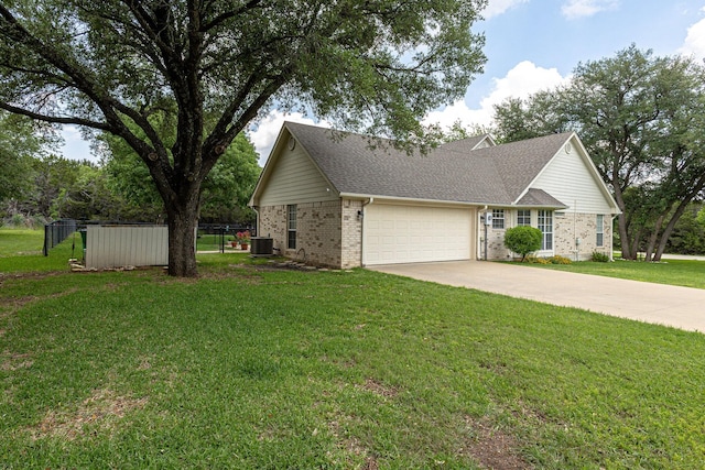 view of front facade featuring cooling unit, a garage, and a front lawn