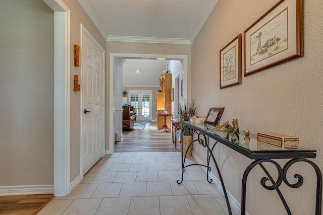 corridor with crown molding, light tile patterned flooring, and french doors