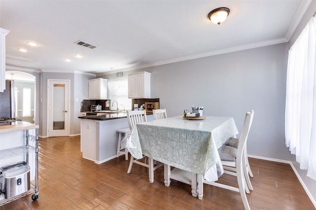 dining space featuring ornamental molding and sink