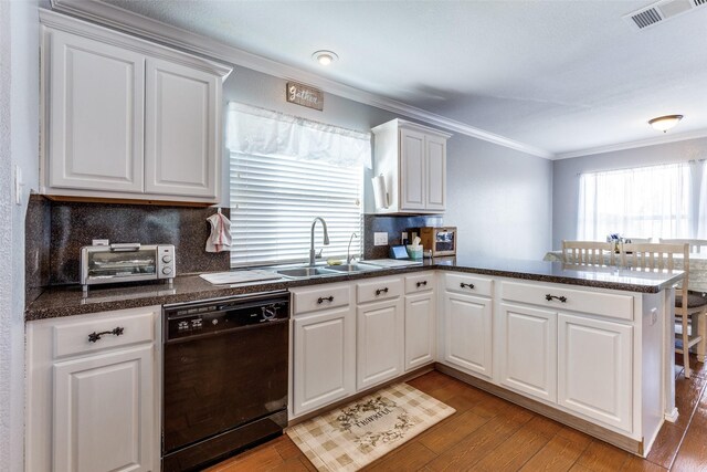 kitchen with kitchen peninsula, tasteful backsplash, black dishwasher, light hardwood / wood-style floors, and white cabinetry