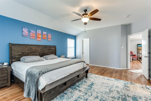 bedroom featuring ceiling fan, light hardwood / wood-style floors, and lofted ceiling