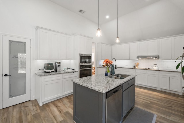 kitchen featuring white cabinetry, stainless steel appliances, sink, and a center island with sink