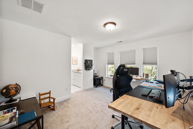 office space with light carpet, visible vents, and baseboards