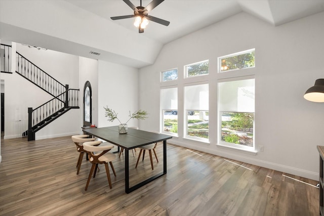 dining room with ceiling fan, high vaulted ceiling, and dark hardwood / wood-style flooring