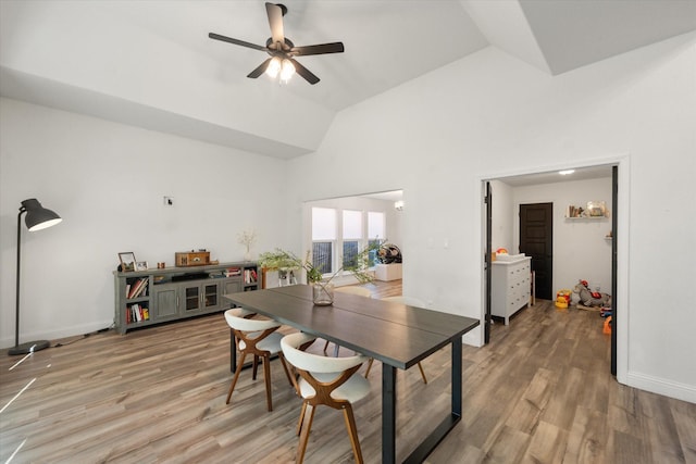 dining room with lofted ceiling, a ceiling fan, baseboards, and wood finished floors