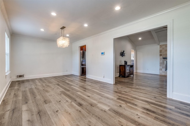 empty room with light wood-type flooring and crown molding