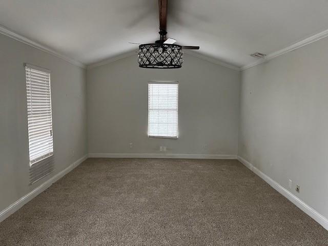 spare room with vaulted ceiling with beams, crown molding, and carpet