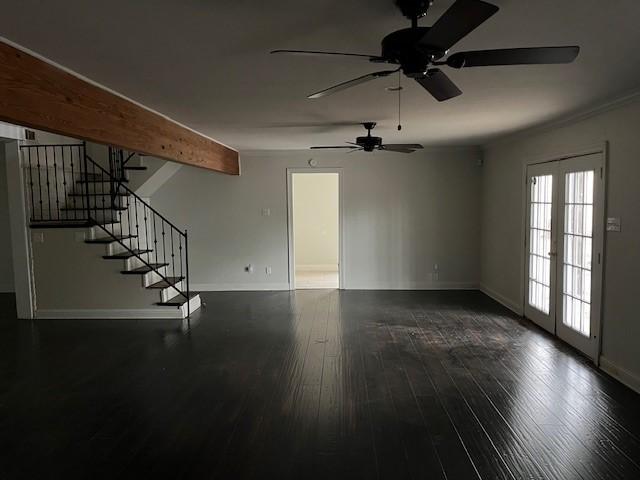 unfurnished living room featuring dark wood-type flooring, beam ceiling, and french doors