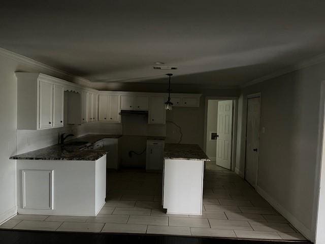 kitchen with sink, white cabinetry, hanging light fixtures, ornamental molding, and kitchen peninsula