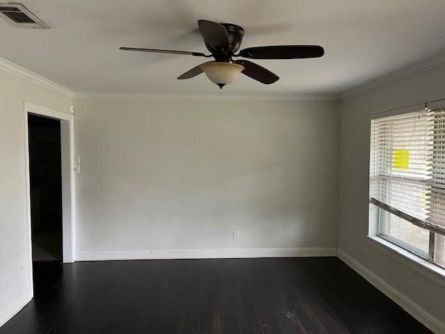 empty room with dark hardwood / wood-style flooring, crown molding, and ceiling fan