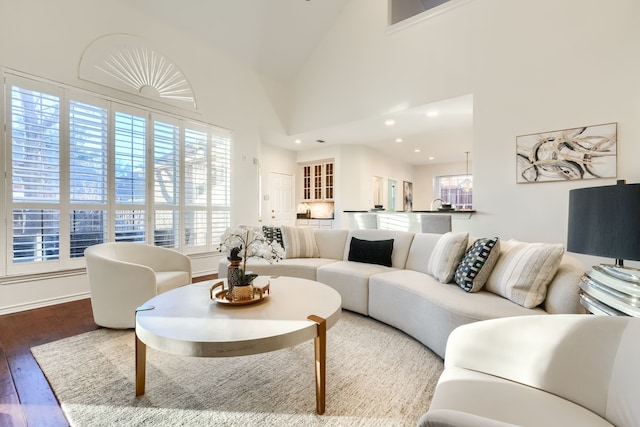 living room with high vaulted ceiling and hardwood / wood-style flooring