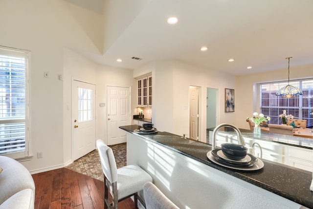 kitchen featuring a wealth of natural light, dark hardwood / wood-style floors, decorative light fixtures, and an inviting chandelier