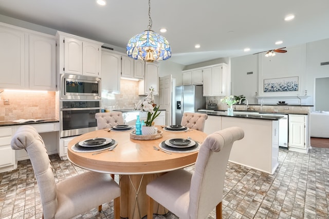 dining space with ceiling fan and sink