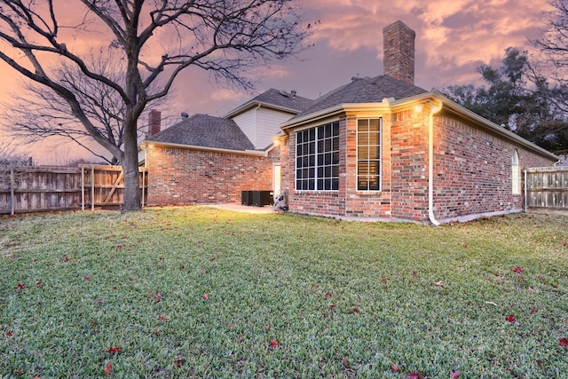 exterior space featuring a yard and central AC