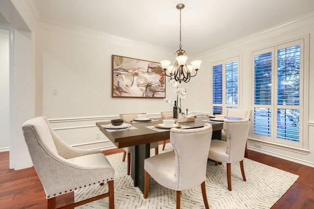 dining area featuring hardwood / wood-style flooring, ornamental molding, and an inviting chandelier