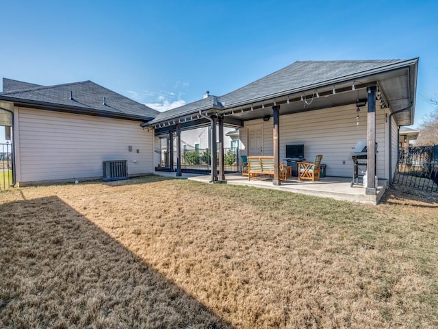 rear view of house featuring a yard, central AC unit, and a patio area