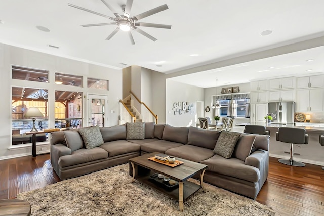 living room featuring ceiling fan and dark wood-type flooring