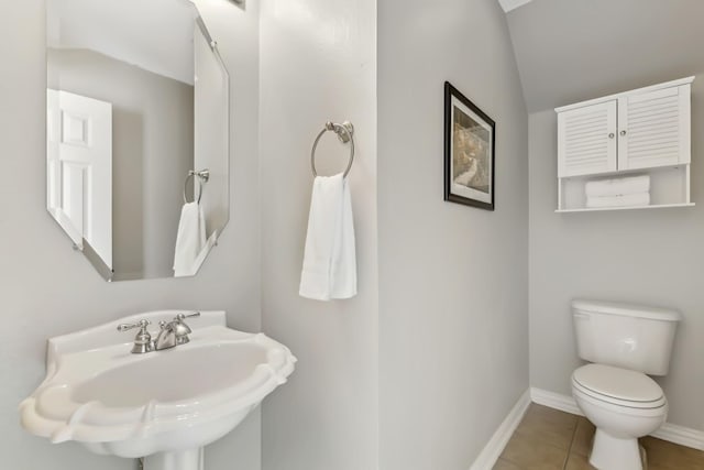 bathroom featuring tile patterned floors, toilet, lofted ceiling, and sink