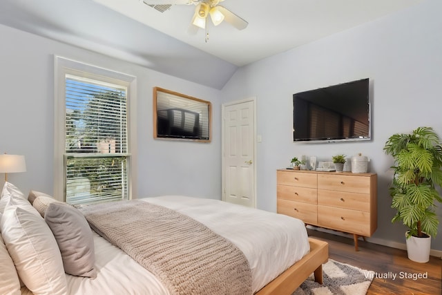 bedroom featuring ceiling fan, dark wood-type flooring, and lofted ceiling