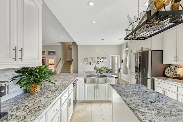 kitchen with sink, white cabinetry, stainless steel appliances, and light tile patterned floors