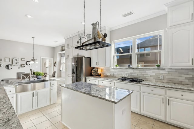 kitchen featuring a center island with sink, stainless steel fridge with ice dispenser, decorative light fixtures, white cabinetry, and gas cooktop