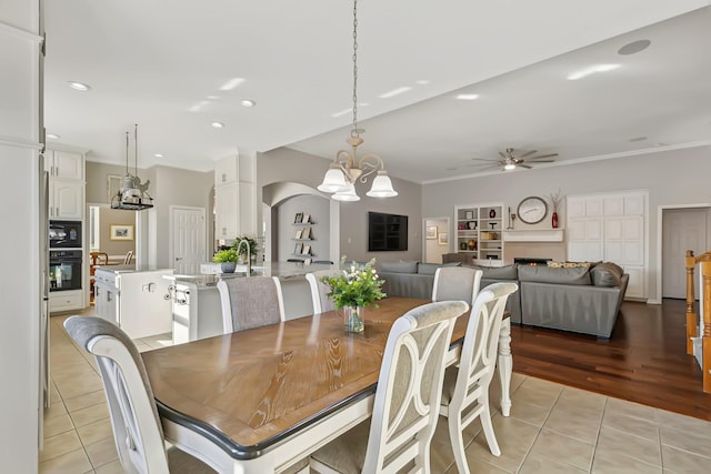 tiled dining space featuring ceiling fan with notable chandelier and ornamental molding