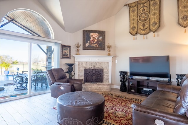 living room featuring high vaulted ceiling, light wood-type flooring, and a brick fireplace