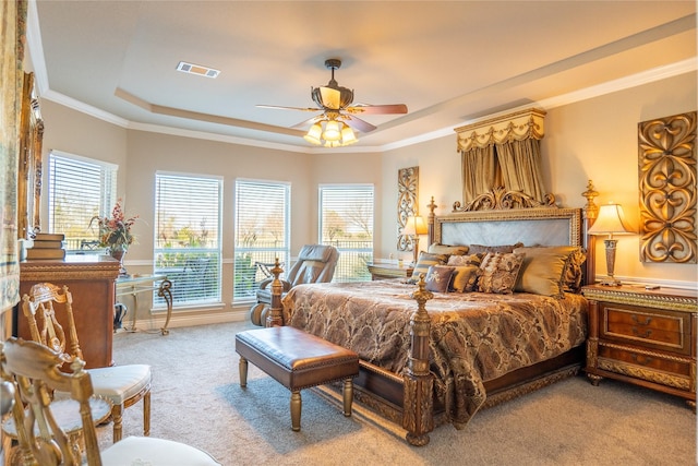 bedroom featuring a tray ceiling, ceiling fan, crown molding, and light colored carpet