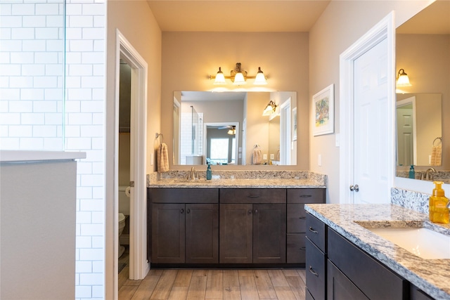 bathroom featuring vanity, hardwood / wood-style flooring, toilet, and ceiling fan