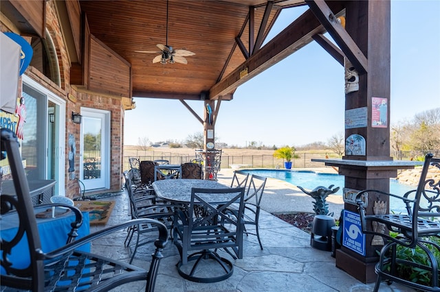 view of patio featuring a rural view, a fenced in pool, and ceiling fan