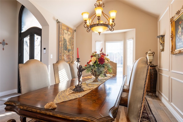 dining space with a chandelier and vaulted ceiling