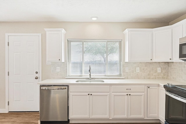 kitchen featuring tasteful backsplash, white cabinetry, sink, and stainless steel appliances