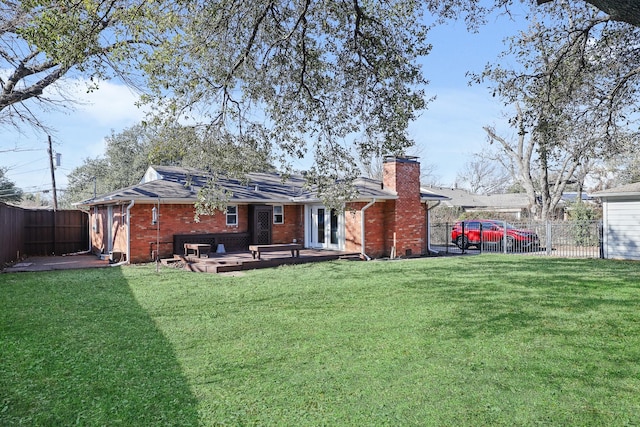 rear view of house featuring a patio area, a yard, and french doors