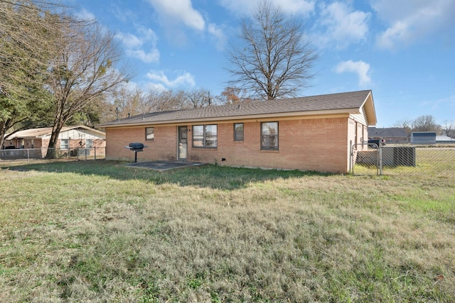 rear view of property featuring a lawn