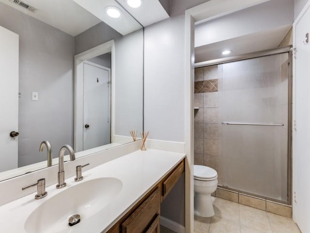 bathroom featuring vanity, toilet, a shower with shower door, and tile patterned flooring