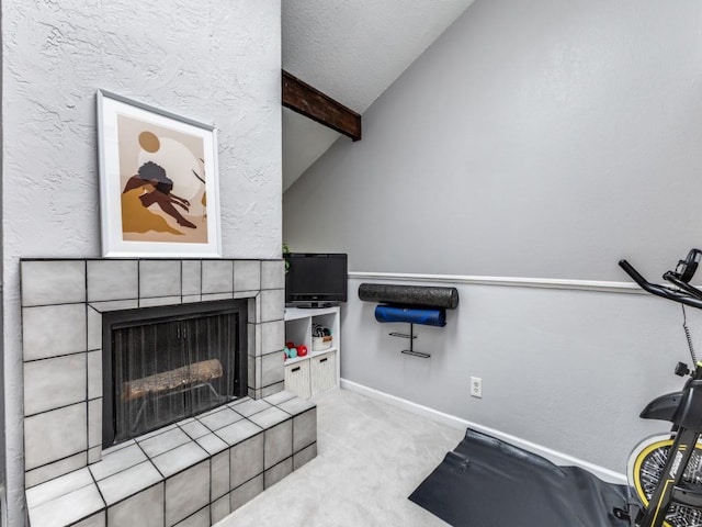 workout room featuring vaulted ceiling, light carpet, and a fireplace