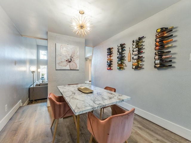 dining room with light hardwood / wood-style flooring and a notable chandelier